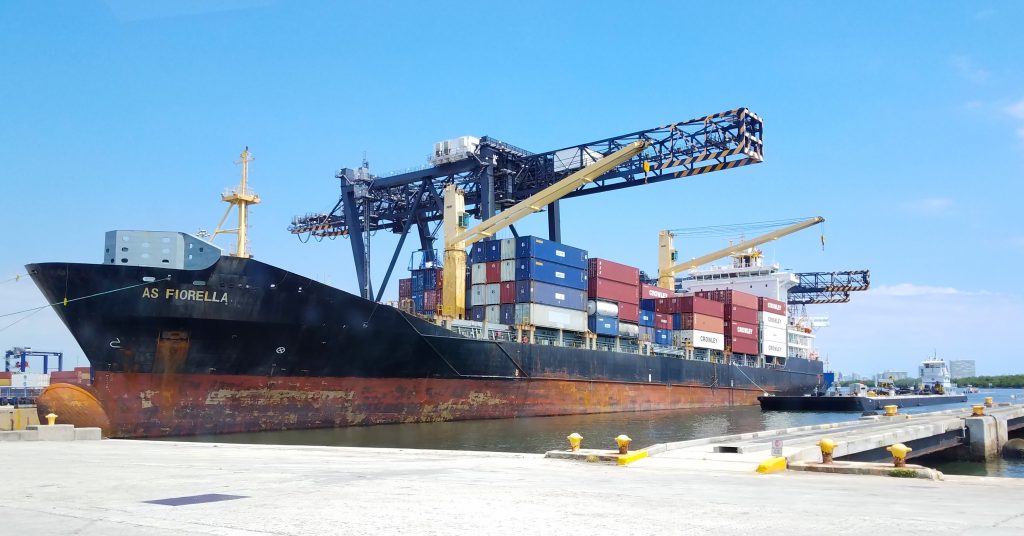 Container ship AS FIORELLA docked at port with cargo containers and loading cranes